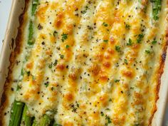 a casserole dish with asparagus and cheese on top, ready to be eaten