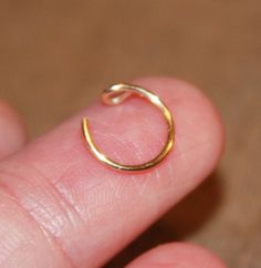 a person's finger with a gold ring on it