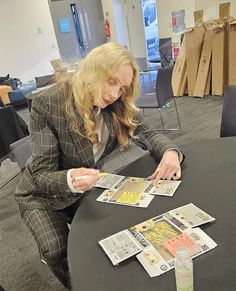 a woman sitting at a table with some money