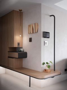 a modern bathroom with wood accents and white walls, along with a plant on the counter