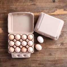 an egg carton filled with eggs on top of a wooden table next to another box