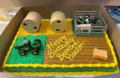 a birthday cake in the shape of a farm scene with tractor, hay and cow