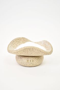 two stone bowls sitting side by side on a white surface with no one around them