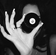 a woman holding up a record in front of her face with the number 8 on it