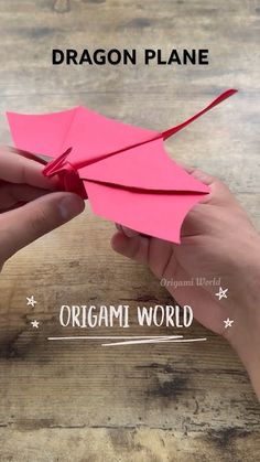 someone is holding a pink origami plane on top of a wooden table with the words dragon plane above it