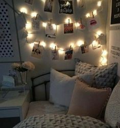 a bedroom with lights strung from the ceiling and pictures hanging on the wall above the bed