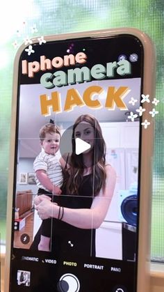 a cell phone with an image of a woman holding a baby in her arms and the words iphone camera hack on it