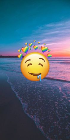 an emoticive smiley face on the beach with hearts floating in the air above it