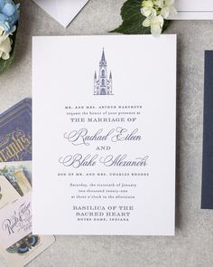 the wedding stationery is laid out on top of the table with flowers and cards