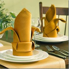 the table is set for two with yellow napkins