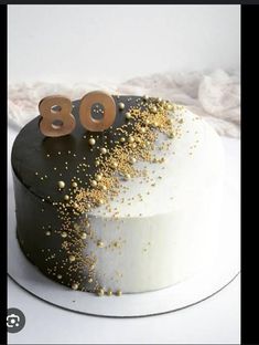 a white cake with gold sprinkles and the number 80 written on it