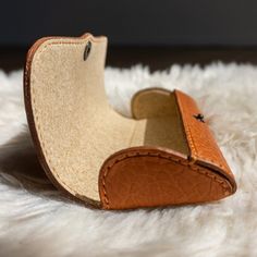 a pair of brown shoes sitting on top of a white rug