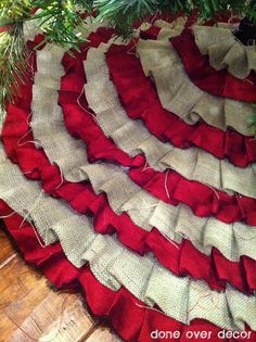 a pile of red and white socks sitting on top of a wooden floor next to a christmas tree