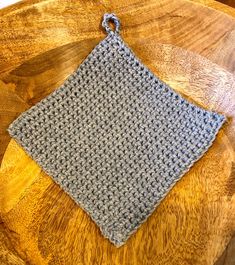 a crocheted square sits on top of a wooden table