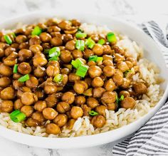 a white bowl filled with rice and chickpeas on top of a marble table