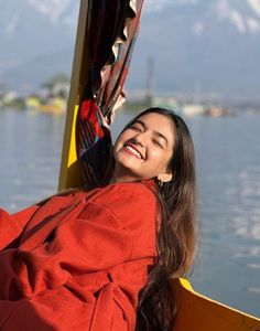 a woman smiles while sitting on a boat