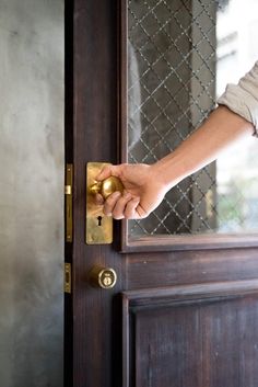 a person's hand is holding the door handle