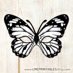 a black and white butterfly cutout on a wooden background with the words, free printable