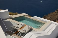 an outdoor hot tub on the roof of a house overlooking water and boats in the ocean