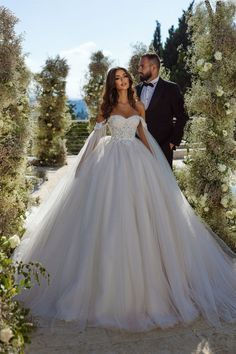 the bride and groom are posing in their wedding gowns