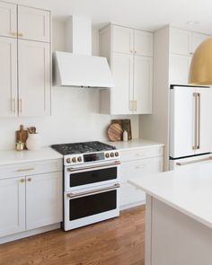 a kitchen with an oven, refrigerator and stove in it's white cabinetry