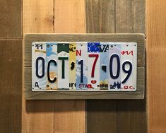 a license plate mounted to the side of a wooden wall that reads oct 11 - 09