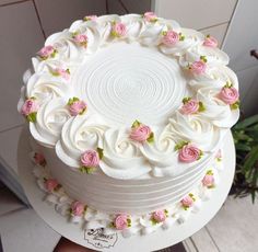 a white cake with pink and green flowers on it