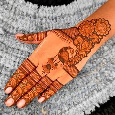 a woman's hand with henna tattoos on it