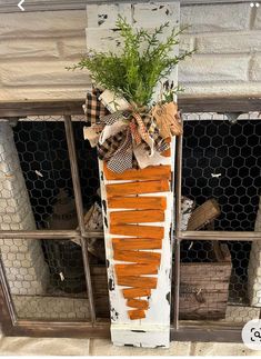 an old window frame is decorated with carrots and greenery