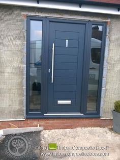 a blue front door on a brick building with glass panels and sidelights, next to a potted plant