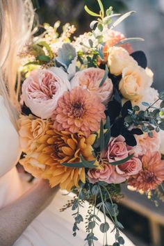 a woman holding a bouquet of flowers in her hands