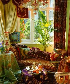 a living room filled with furniture and a chandelier hanging from the ceiling next to a window