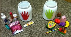 two white jars with handprinted designs on them are sitting on the floor next to other items