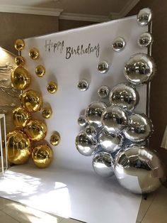 a happy birthday sign with balloons and confetti on the table in front of it