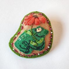 a green brooch with a red bow on it