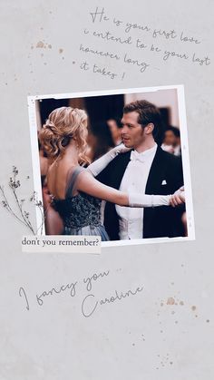 a man and woman are dancing together in front of a white wall with writing on it