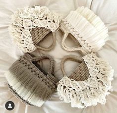 three crocheted slippers on top of a white bed next to each other