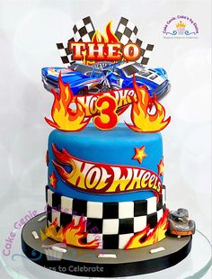 a birthday cake decorated with hot wheels and flames