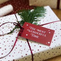 a present wrapped in white and red paper with the words the most wonderful time on it