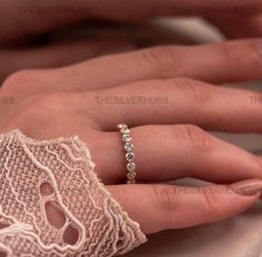 a woman's hand with a wedding ring on her left hand and the other hand holding