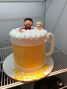 there is a cake made to look like a beer mug with a man in it