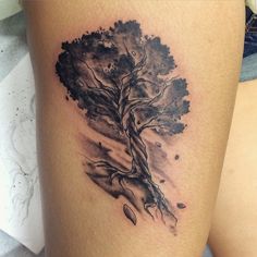 a tree tattoo on the thigh