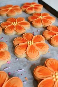 cookies decorated with orange flowers on a baking sheet