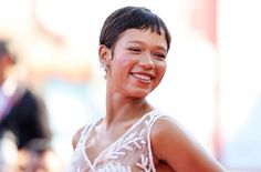 a woman in a white dress smiling at the camera