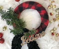 a christmas wreath with the word love spelled out on it and other holiday decorations around it