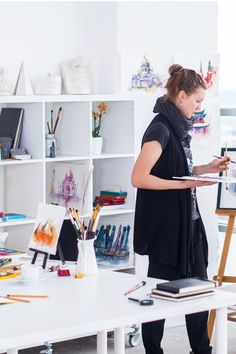 a woman is painting in an art studio