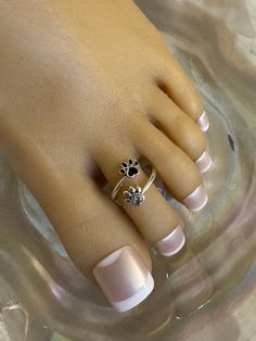 This silver toe ring features two paw prints. one has black enamel and the other has a crystal accent that adorns the toe. It is size adjustable and one size fits most. Comfortable and versatile, it will lend itself to casual or formal events. All items are made in a smoke free environment. *If there is any issue with your toe ring, please let me know so that I can correct it. Thanks for visiting my shop! 👣 Adjustable Silver Jewelry With Paw Print, Adjustable Paw Print Jewelry For Anniversary, Adjustable Nickel-free Silver Toe Rings, Adjustable Sterling Silver Paw Print Jewelry, Adjustable Sterling Silver Jewelry With Paw Print, Adjustable Nickel-free Toe Rings As Gift, Hypoallergenic Silver Toe Rings As Gift, Cryptidcore Outfit, Toes Ring Silver