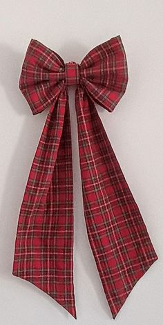 a red and black plaid bow on a white background