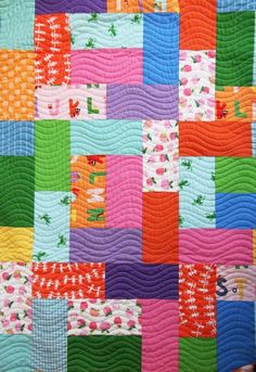 a colorful quilt is hanging on the wall