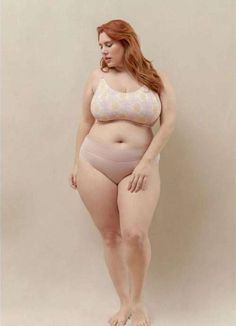 a woman in a pink and white bra posing for the camera with her hands on her hips